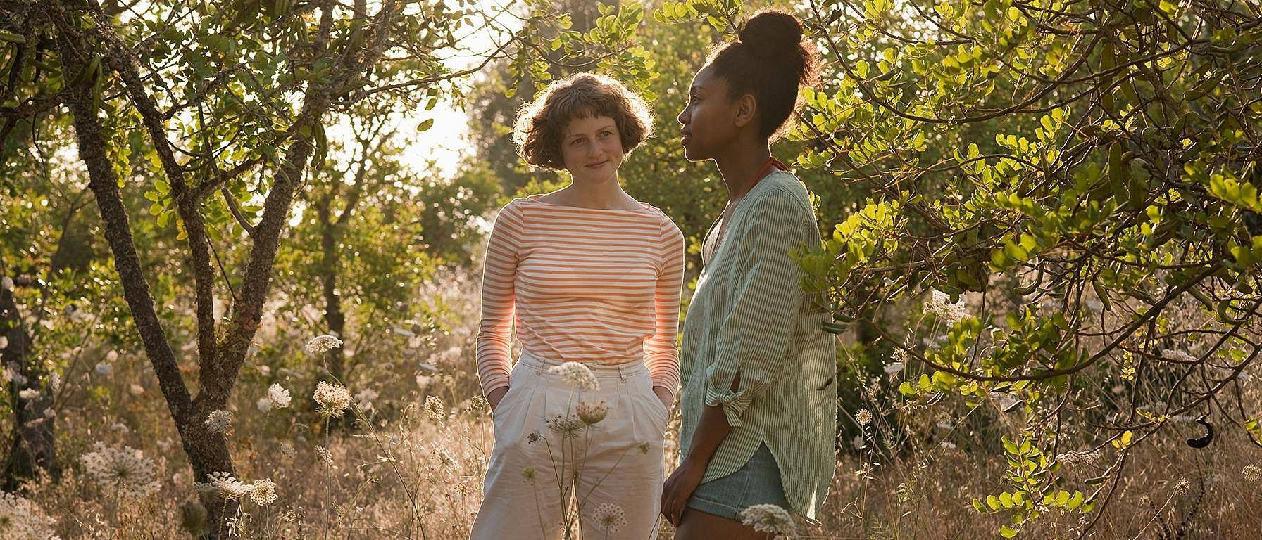 two women walking in orchard