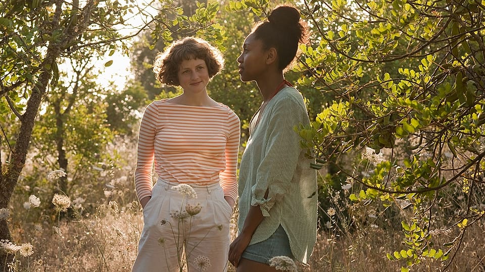two women walking in orchard